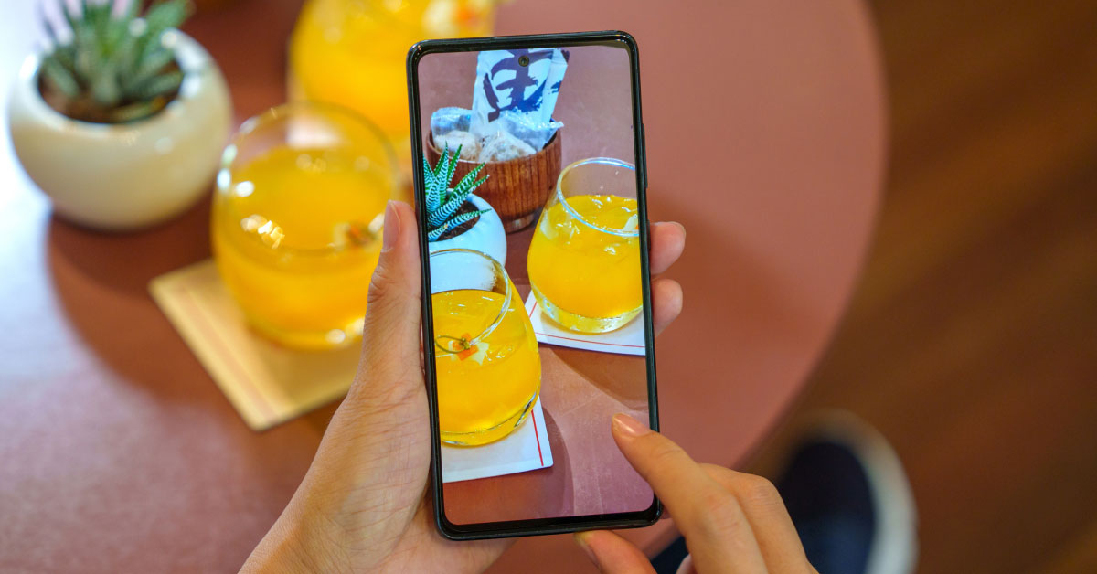 person photographic pitchers of juice with their phone